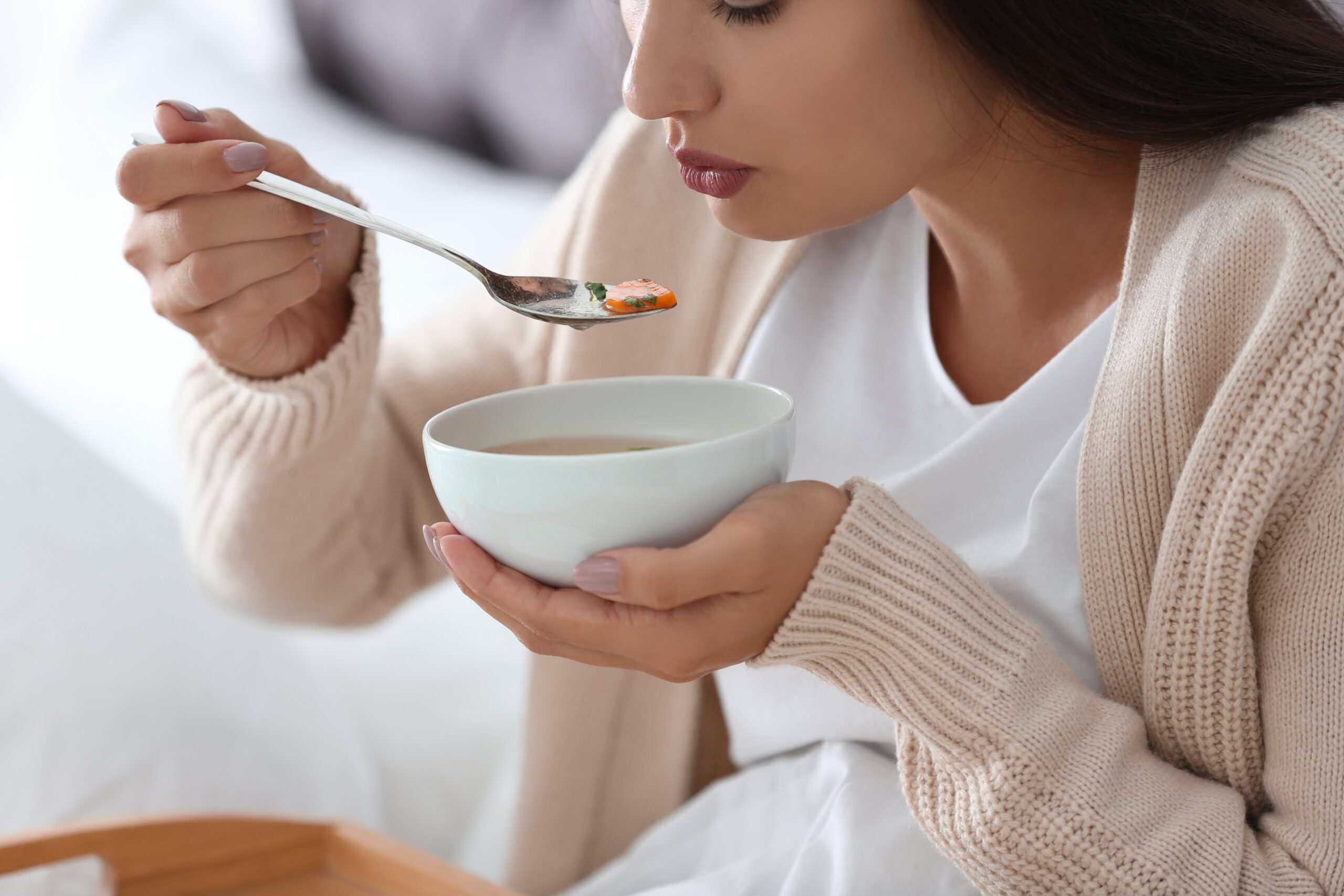 Sick woman eating soup